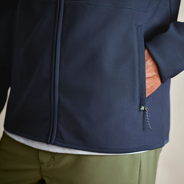 Navy blue jacket with a brown leather patch on a beige background