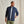 Load image into Gallery viewer, Man wearing a navy jacket over a light grey shirt with green pants against a beige background
