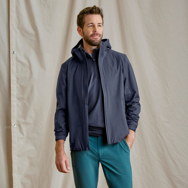 man modelling dark blue jacket and half zippet jumper and green pants