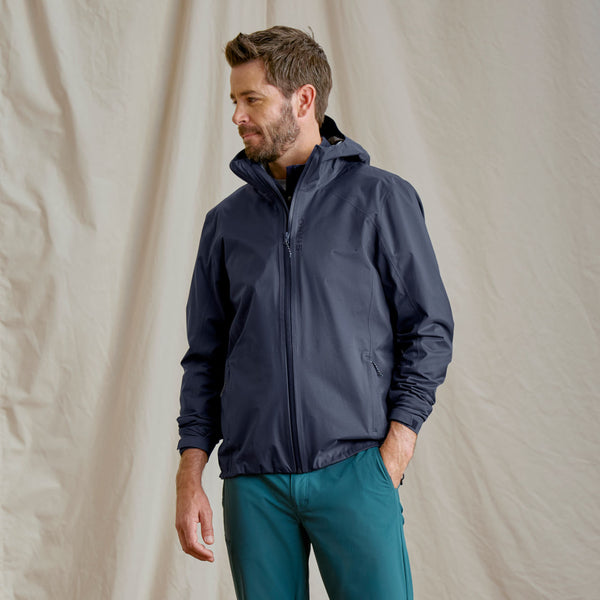 man wearing dark blue jacket and green pants looking to the left side