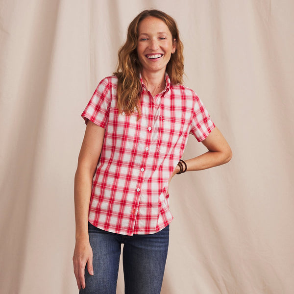 woman laughing wearing red and white shirt infront of white background