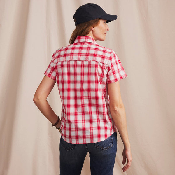 woman wearing red and white checkered shirt in front of beige background