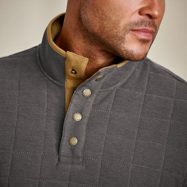 Grey quilted jacket with beige collar and buttons on a neutral background