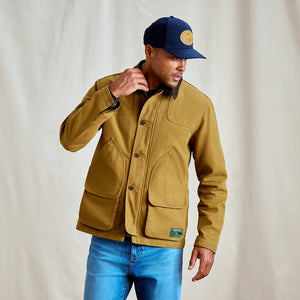 man wearing beige jacket and blue cap