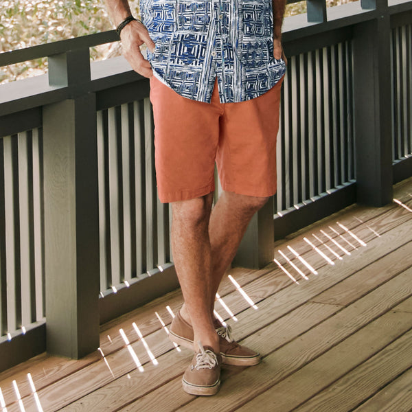 man wearing orange shorts and beige sneakers