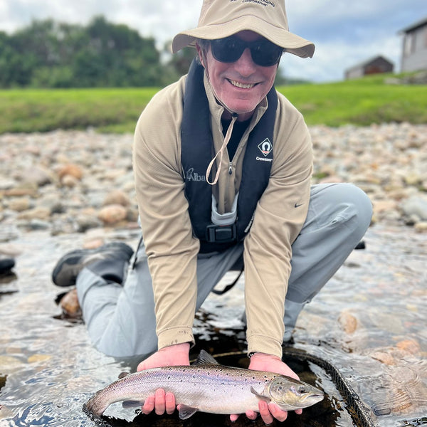 man smiling to camera while holding fish