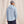 Load image into Gallery viewer, man with his back to the camera wearing cap, light blue hoodie and dark blue pants in front of beige background
