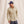 Load image into Gallery viewer, man wearing beige shirt, blue pants and caps in front of beige background
