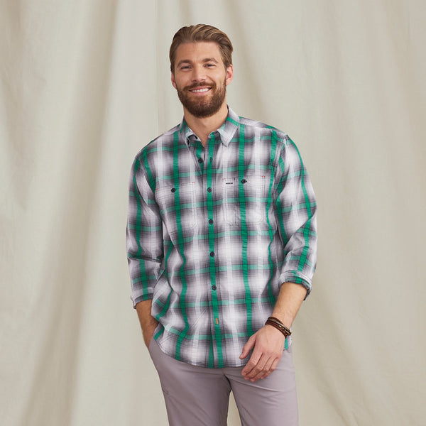 man smiling to camera wearing checkered shirt