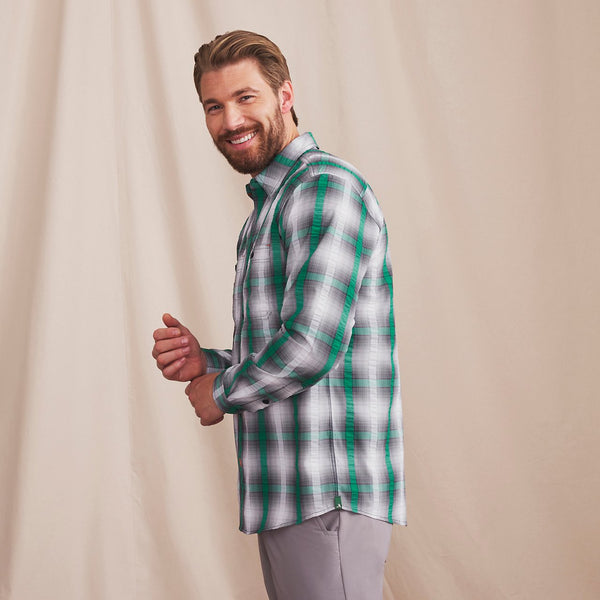 man smiling to camera wearing green and black shirt