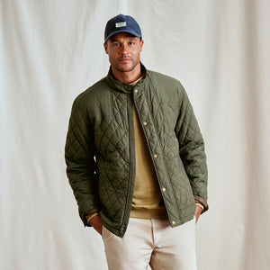 Man wearing blue cap, green jacket and beige sweater