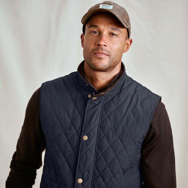 man wearing blue vest and brown cap