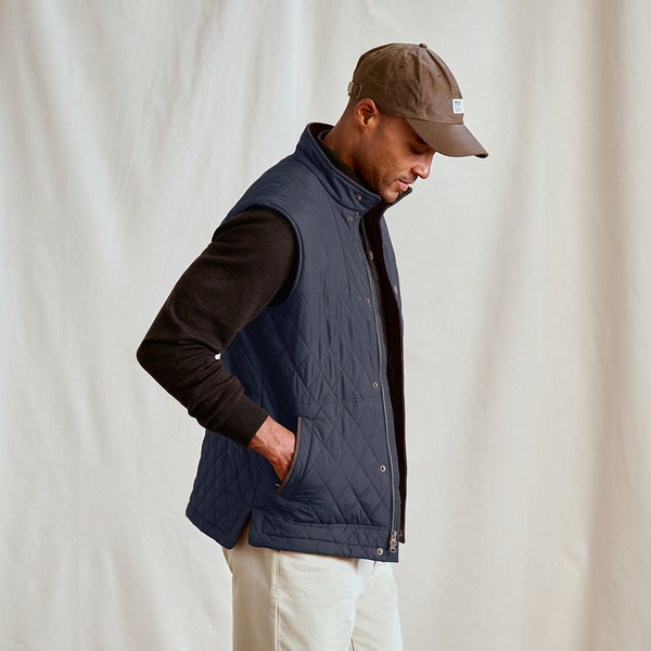 man wearing blue vest and brown cap