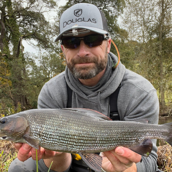 fly fisher showing fish to the camera