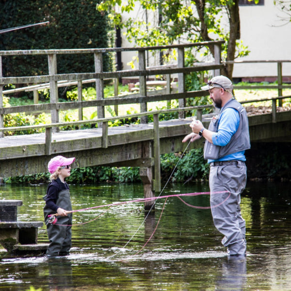 man showing child how to fly fish