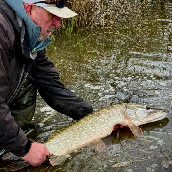 man showing fish over water