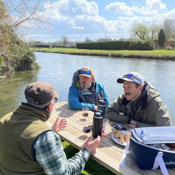 fly fishers sat on table next to river