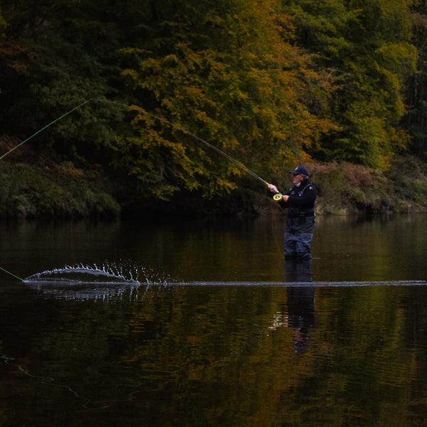 man fly fishing in river