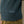 Load image into Gallery viewer, Close-up of a person wearing a dark teal speckled knit sweater with 'FERA' embroidered in white near the ribbed hem, paired with olive green trousers.
