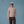 Load image into Gallery viewer, A man stands against a solid blue studio backdrop wearing a light beige crewneck sweater, dark brown corduroy pants, brown leather shoes, and a cream baseball cap.
