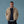 Load image into Gallery viewer, Man wearing a beige jacket, navy sweater, black shorts, and brown shoes against a blue background
