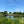 Load image into Gallery viewer, lake surrounded by greenery and blue skies
