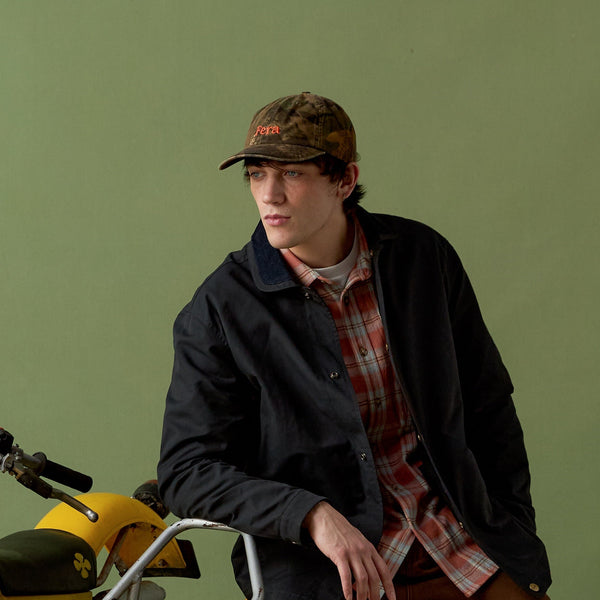 Person sitting on a yellow motorcycle against a green background
