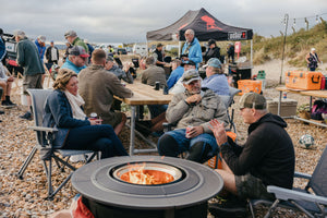 people around campfire on the beach