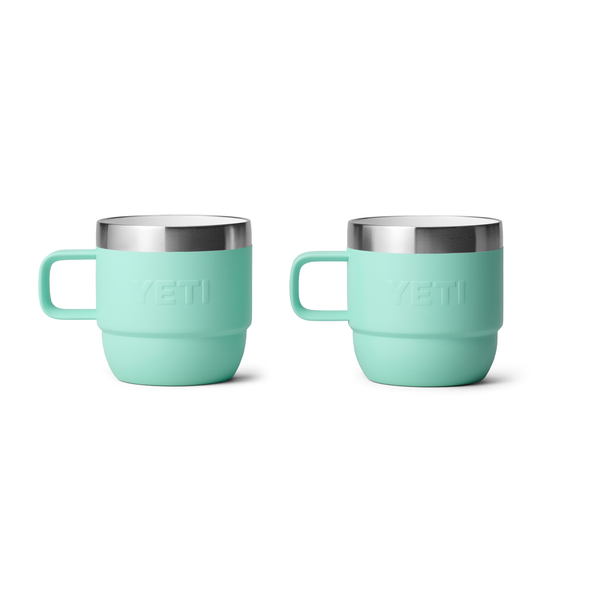 Two turquoise mugs with silver rims on a white background