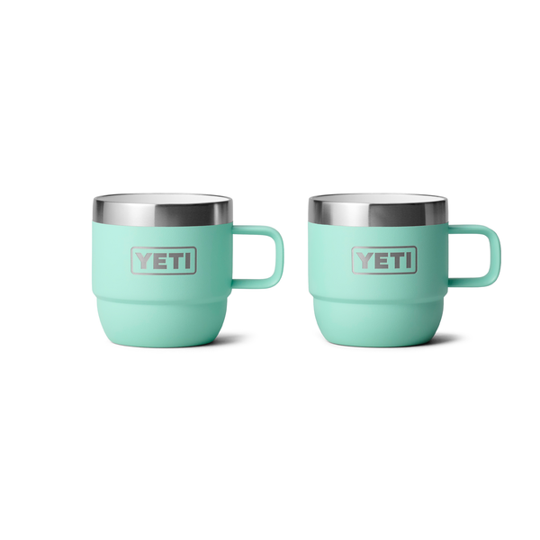 Two turquoise YETI mugs with silver handles on a white background