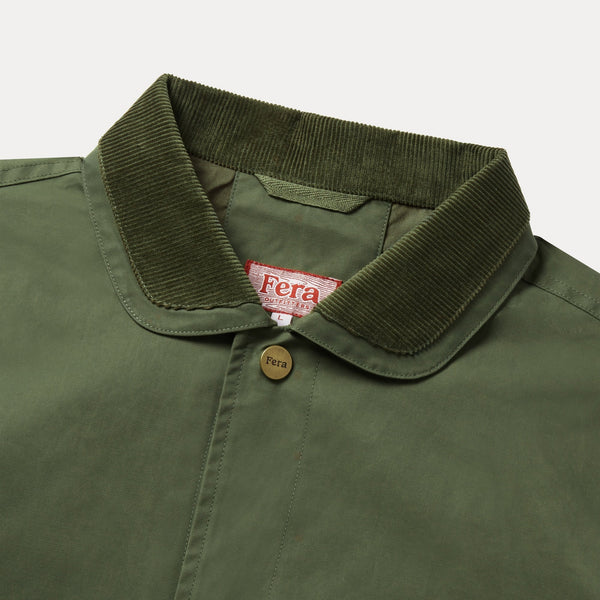 Close-up of an olive green Fera button-up shirt featuring a ribbed corduroy collar, brass-tone buttons, and an embroidered Fera logo on the chest.