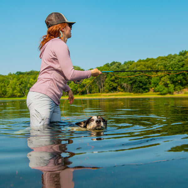 An angler and her dog fishing in the river
